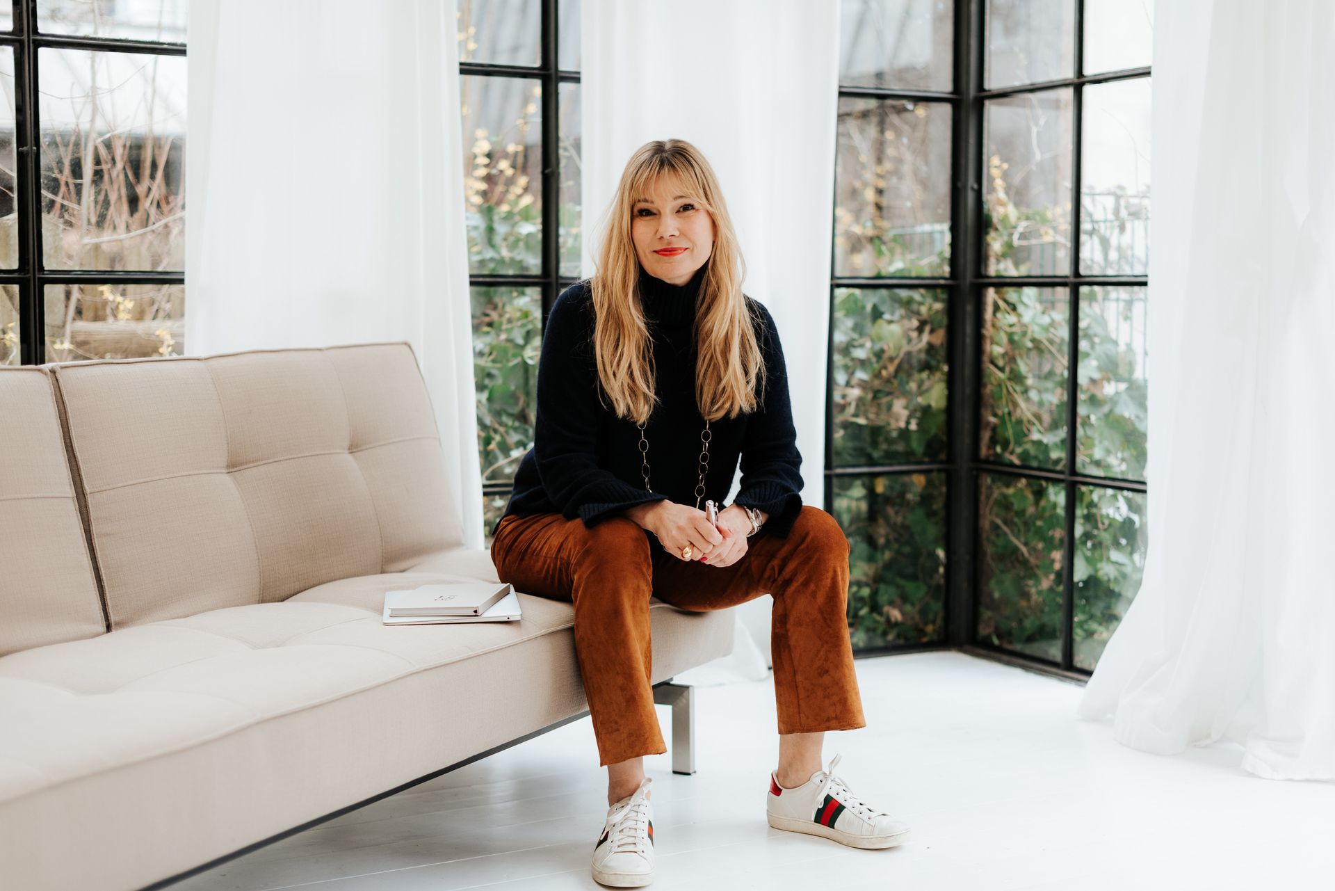 Carolyn Schlak sitzt auf einem Sofa