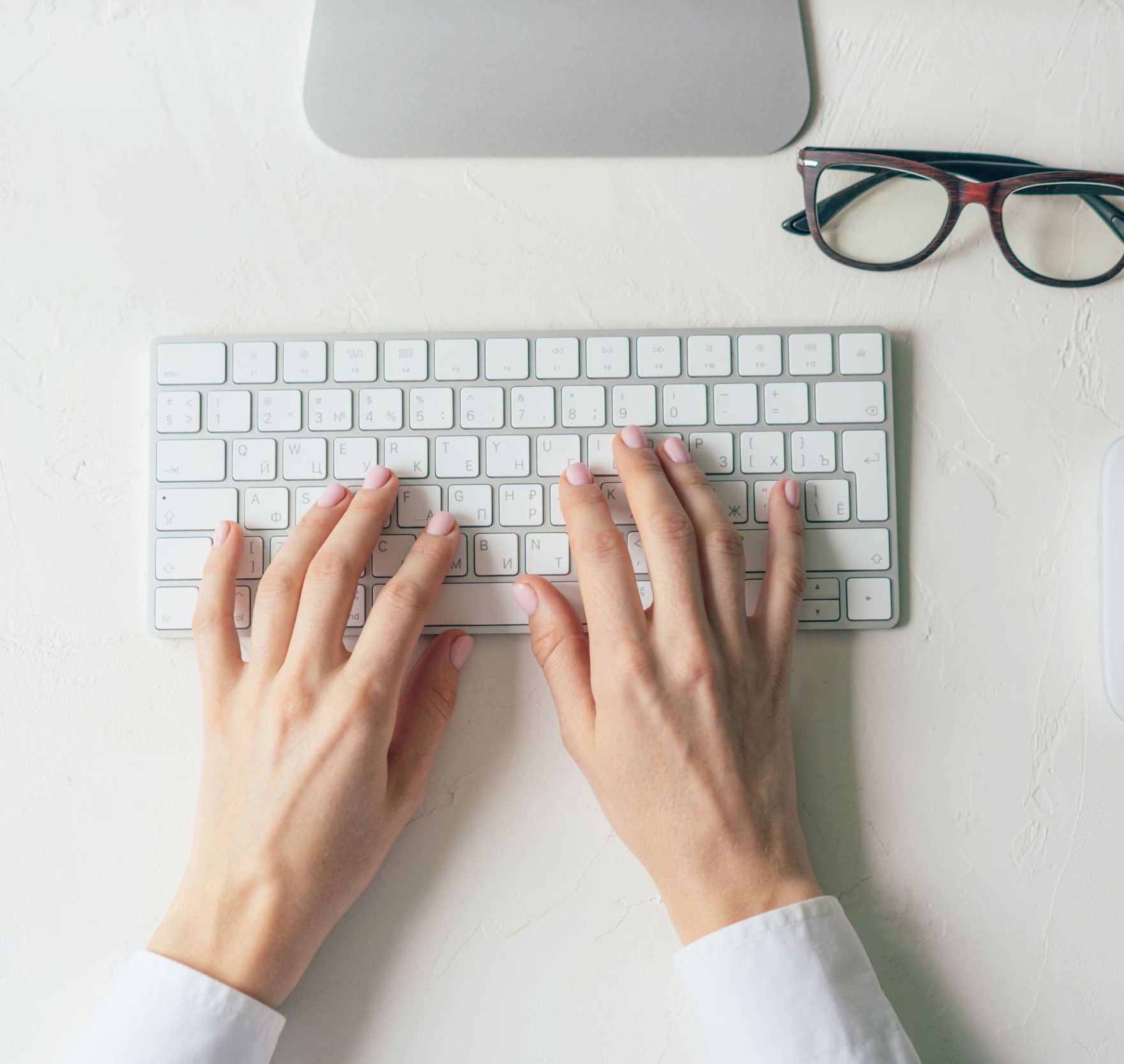 A woman is sitting at a desk using a laptop computer.