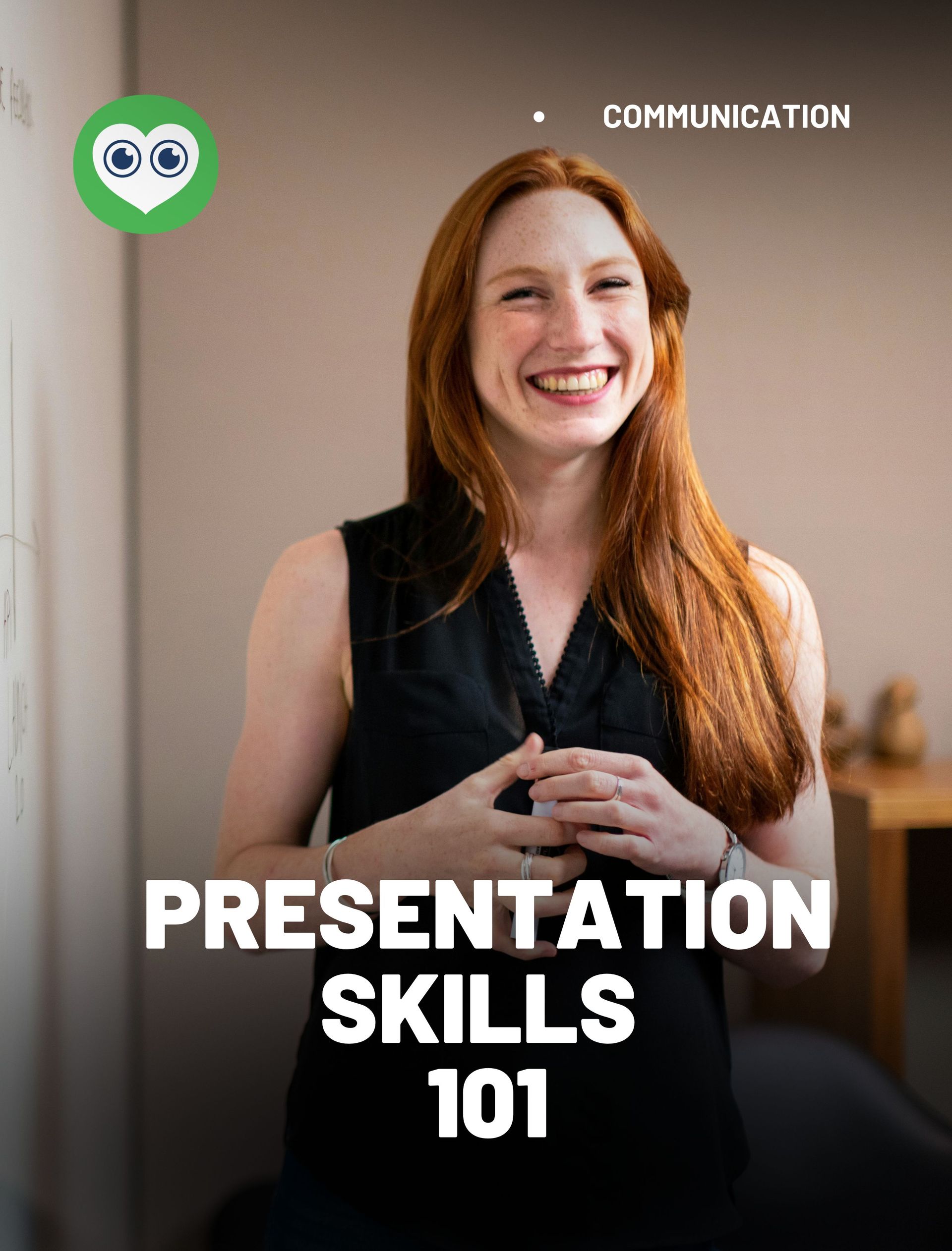 A woman with red hair is standing in front of a wall and smiling.