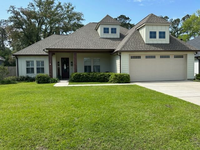 A picture of the front of a tan house with seamless gutters in covington, LA