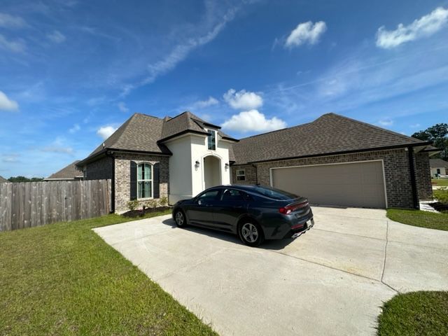 A side view picture of a brick and stucco house with seamless gutters in Covington, LA