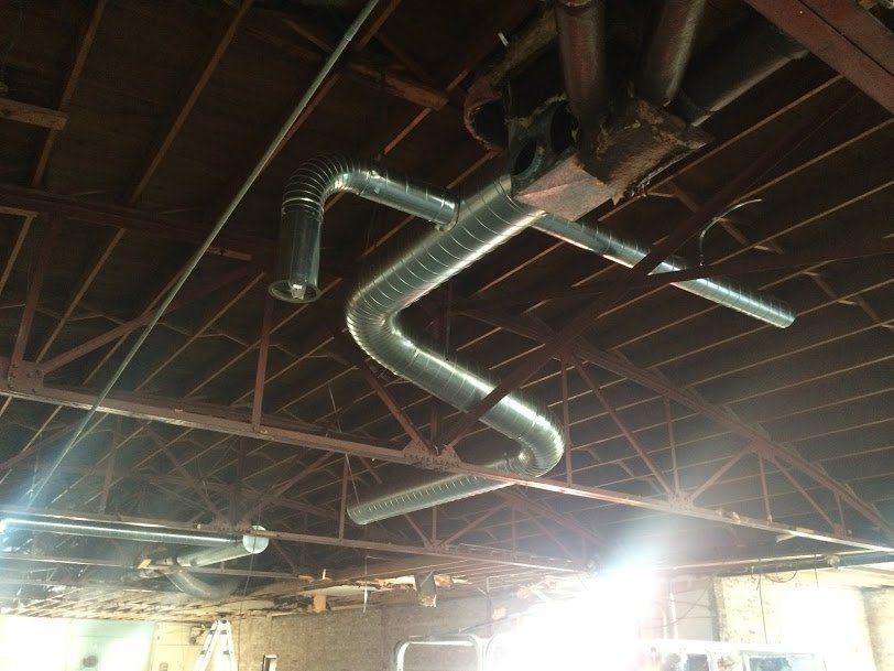 A ceiling with a lot of pipes hanging from it