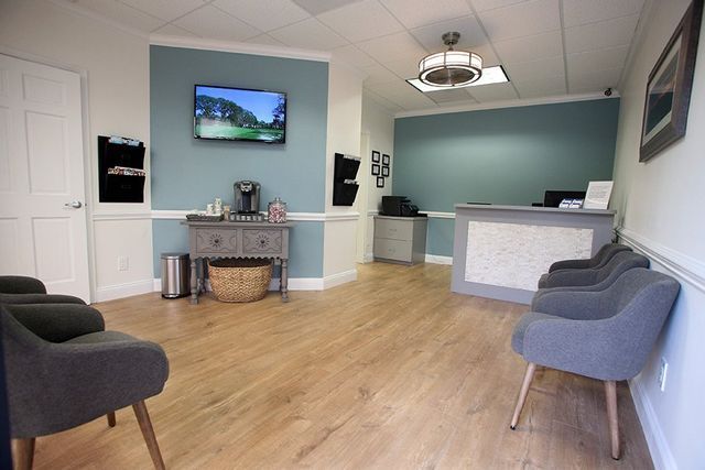 A waiting room with chairs and a television on the wall.