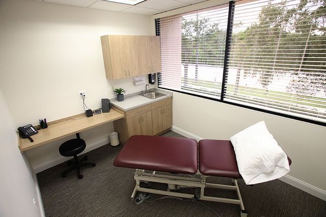 A doctor 's office with a table and a sink