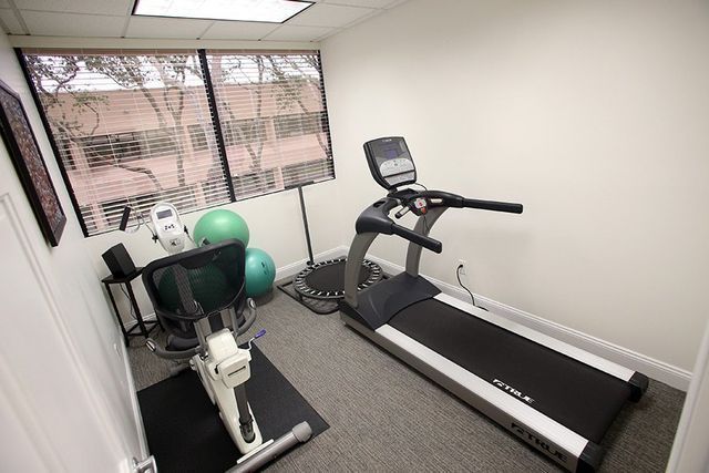 There is a treadmill and a bike in the room.