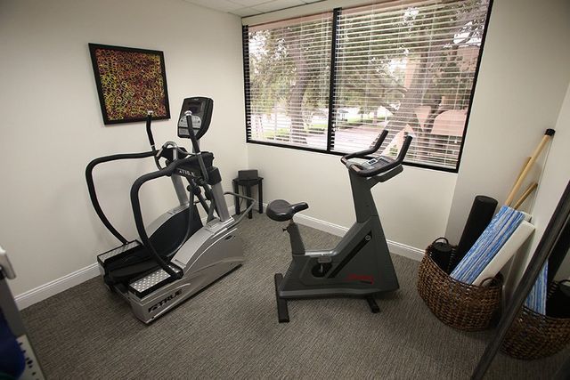 A room with two exercise bikes and an elliptical