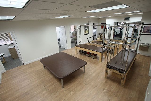 An aerial view of a physical therapy room with a table and a pilates machine.