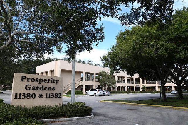 A sign for prosperity gardens is in front of a building
