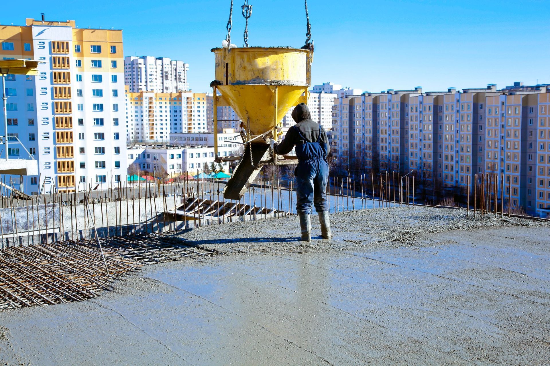 Skilled construction workers in hard hats pouring concrete at a commercial building site