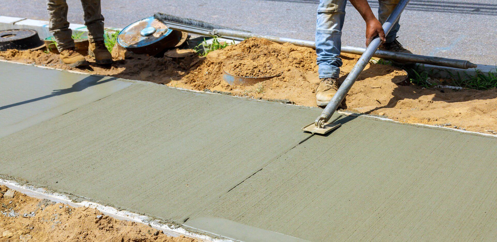 Two workers smoothing concrete they are working on