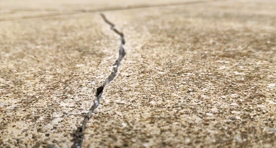 Textured concrete surface with a narrow crack.