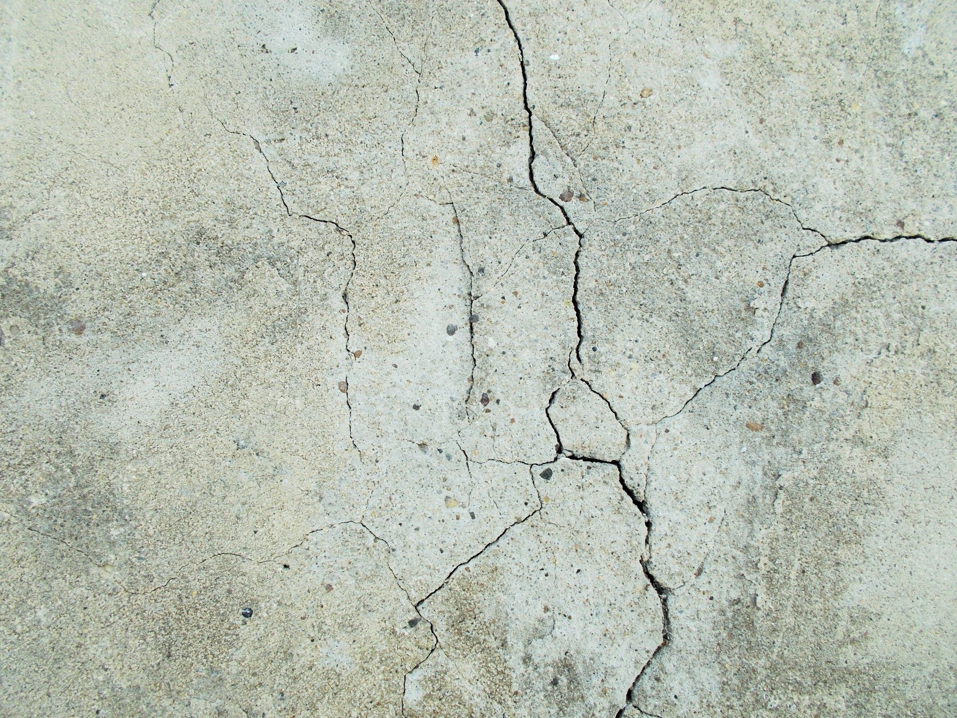 Cracked gray concrete surface with visible lines and textures.