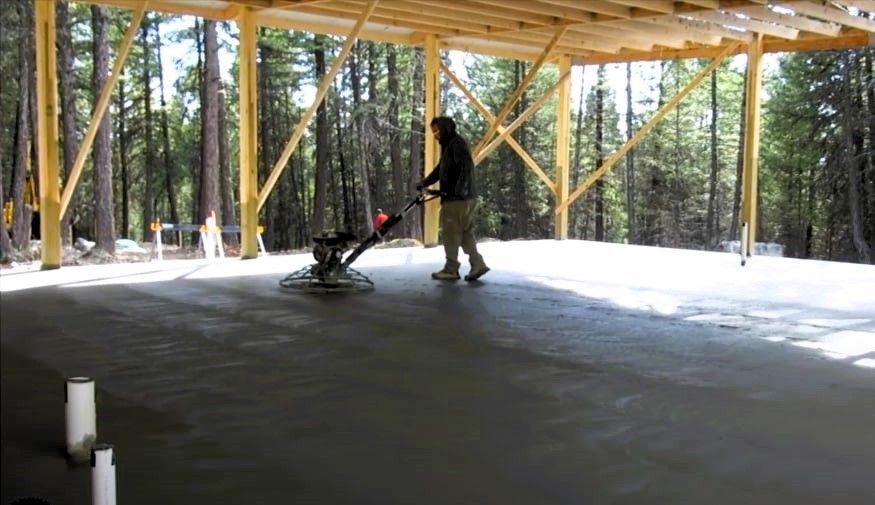 Expert meticulously working on the concrete flooring of a pole barn