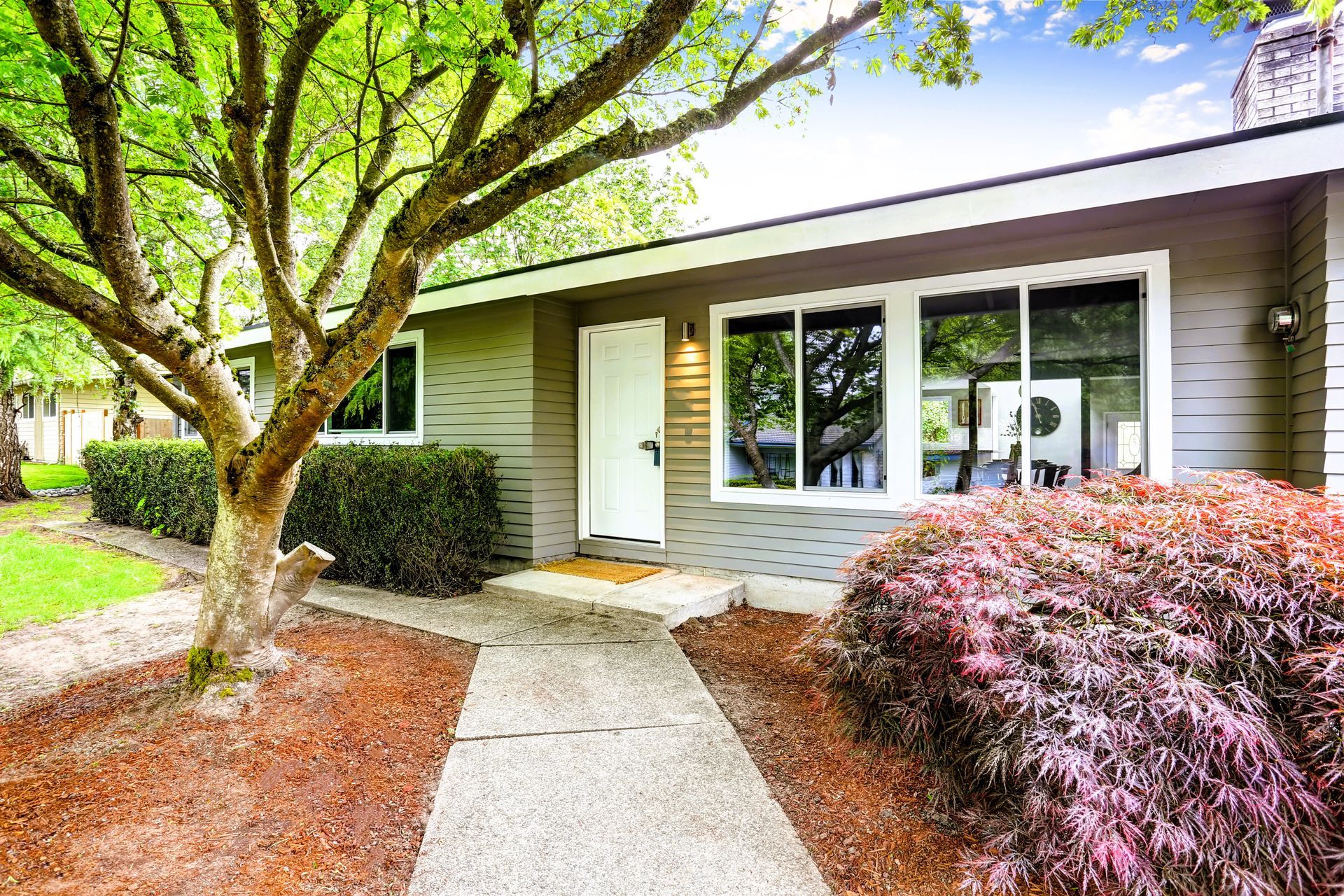 One level house exterior with concrete walkway and garden in Grand Rapids, MI