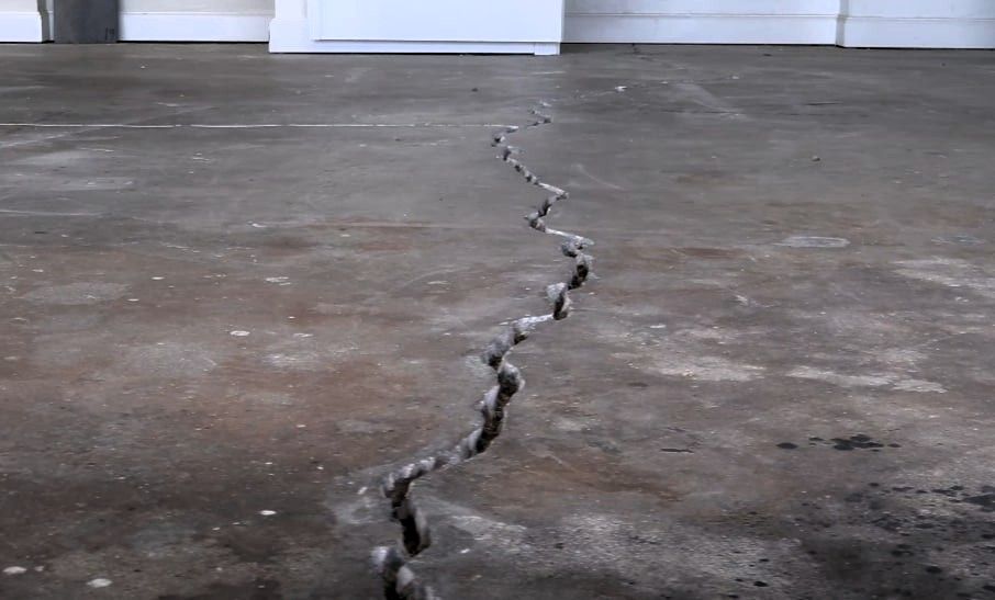 Garage floor concrete crack close-up highlighting foundation and surface issues