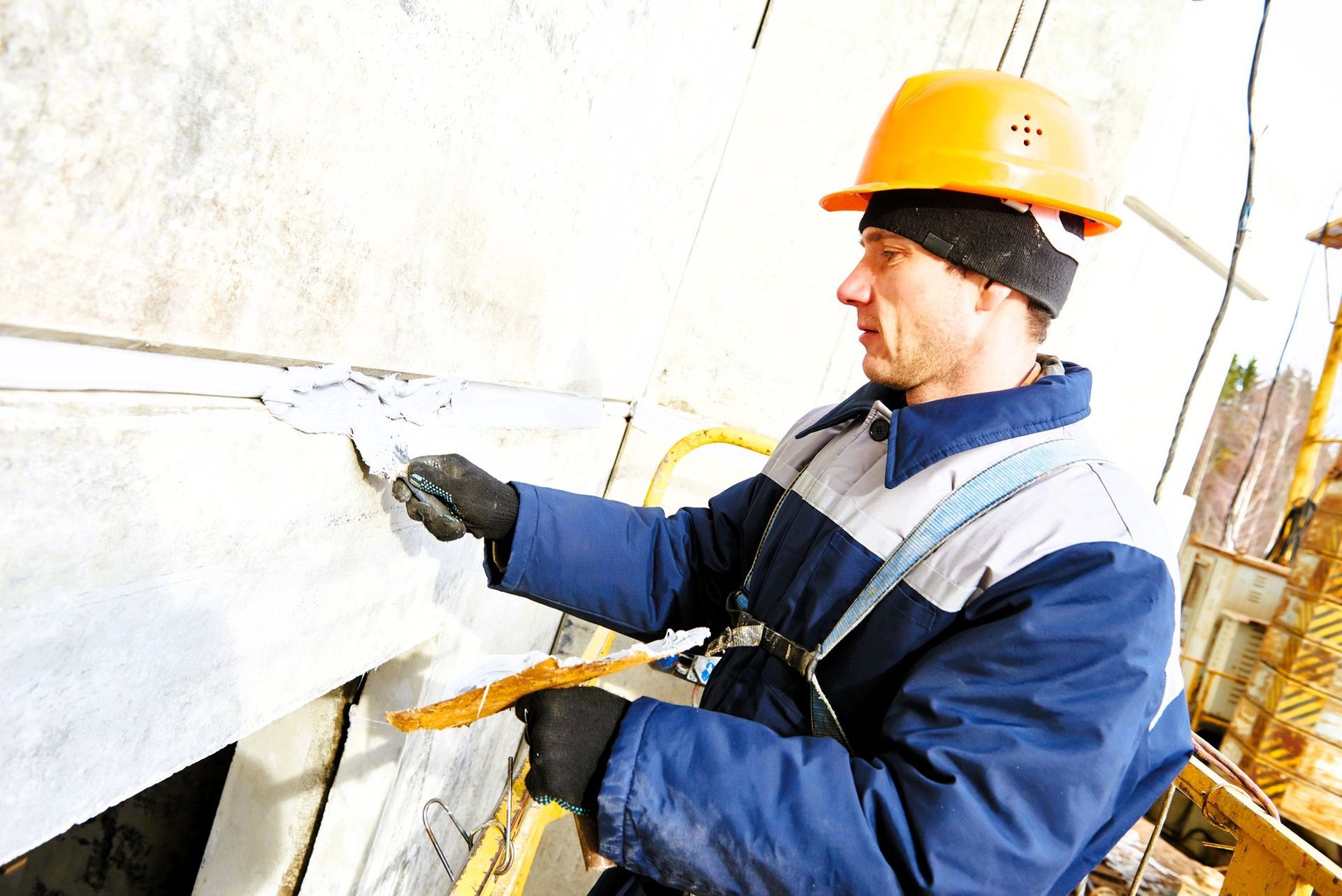 Local residential concrete contractor applying sealant to a concrete wall