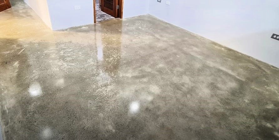 A freshly polished concrete floor transitioning from a glossy finish to its original matte texture.