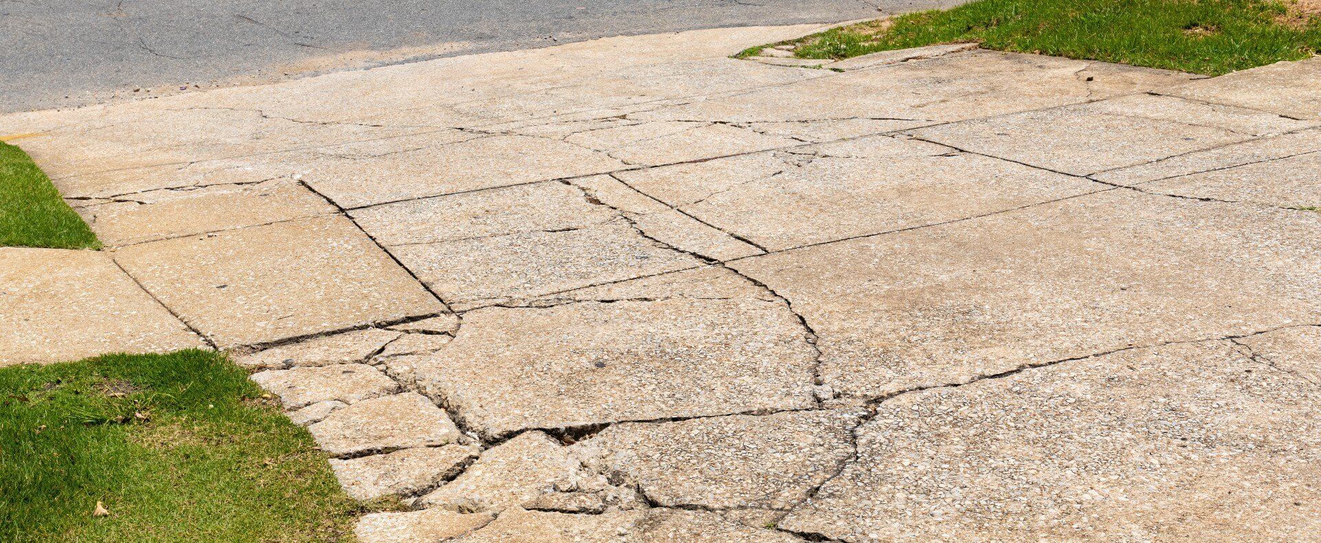 Cracks and damage in a concrete driveway