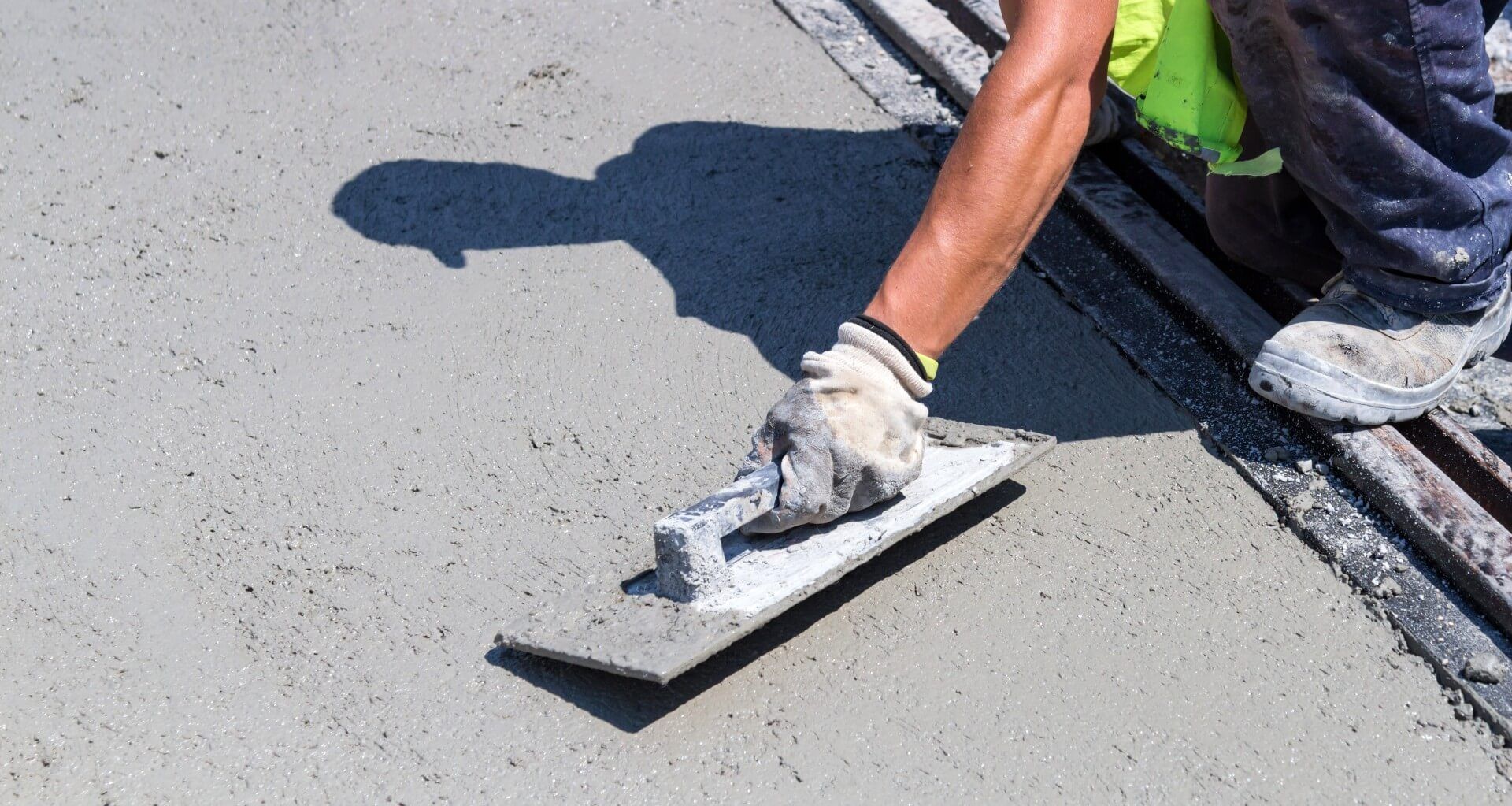 Concrete contractor doing a trowel finish on the wet concrete