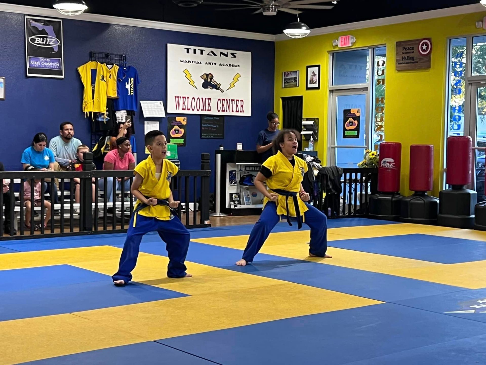 A group of people are practicing martial arts in a gym.