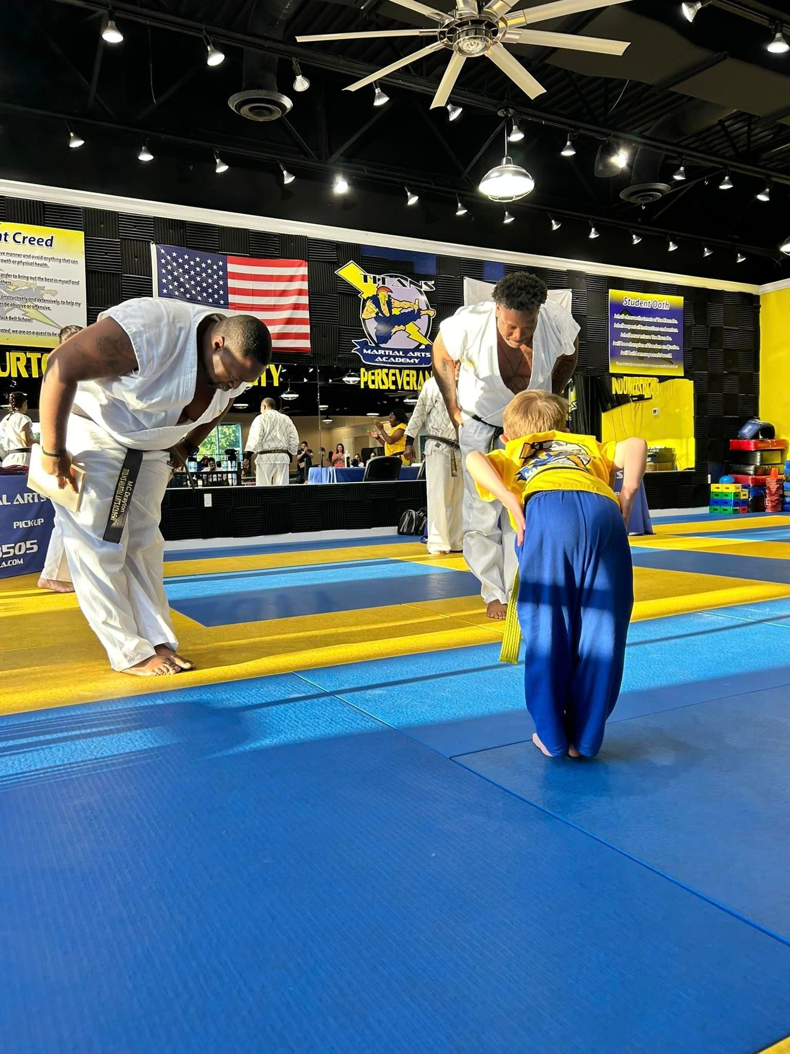 A group of people are practicing martial arts in a gym.