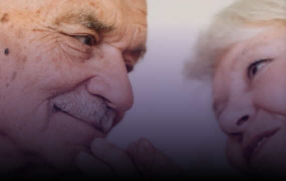 Elderly couple, side by side, looking at each other affectionately, sharing a tender moment.