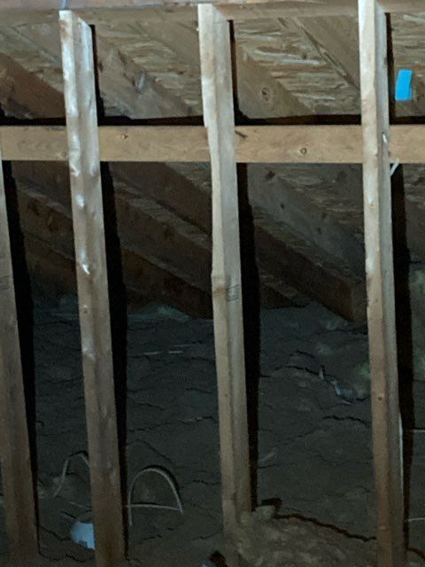 Inspection photograph of a soffit area in an attic where the blown insulation has covered the vents.