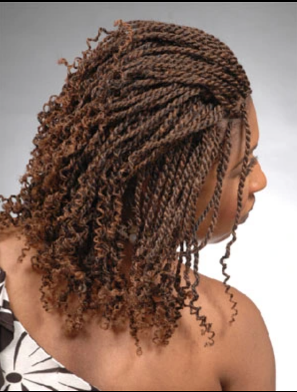 A woman with braids and curly hair looks over her shoulder