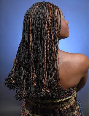 A woman with long braided hair is wearing a floral top