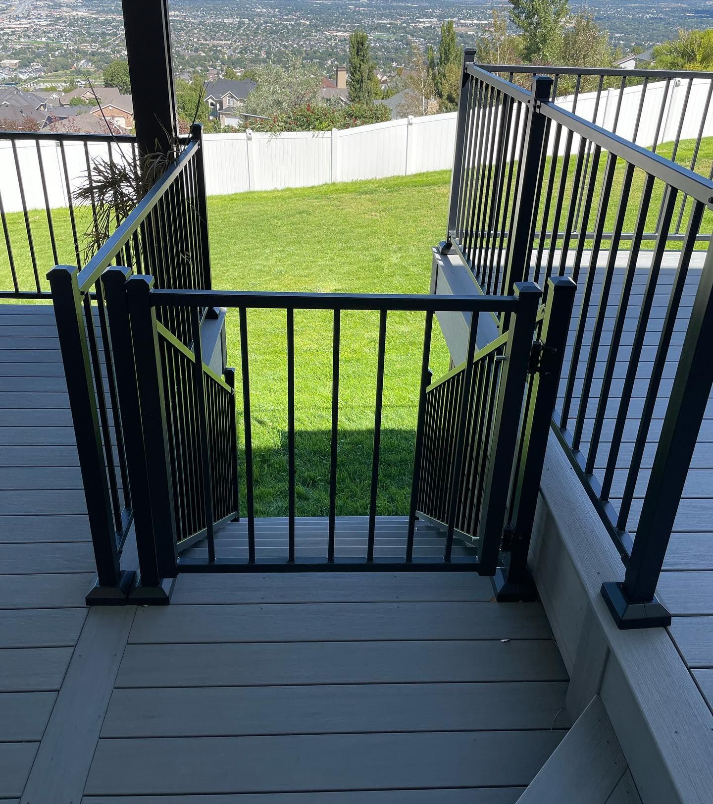 A staircase with a gate leading to a lush green field.