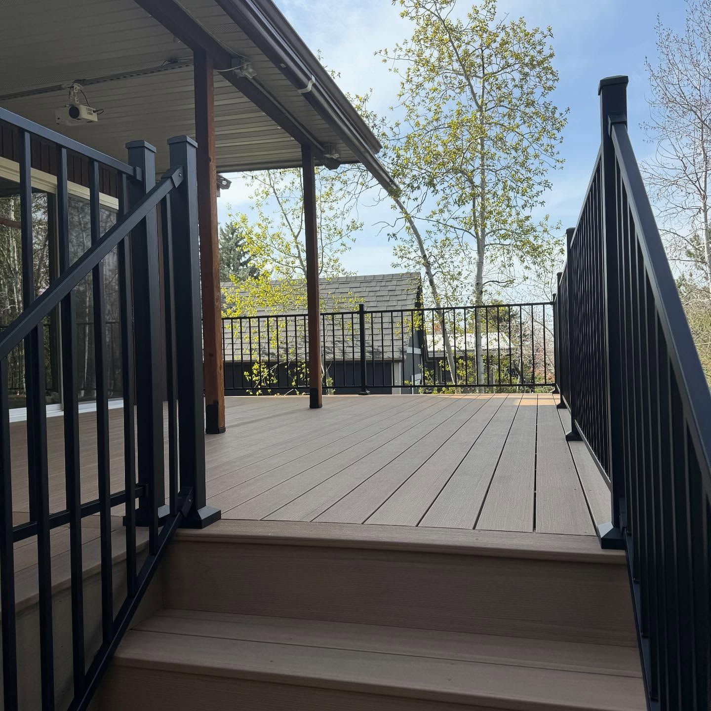 Stairs leading up to a deck with a black railing