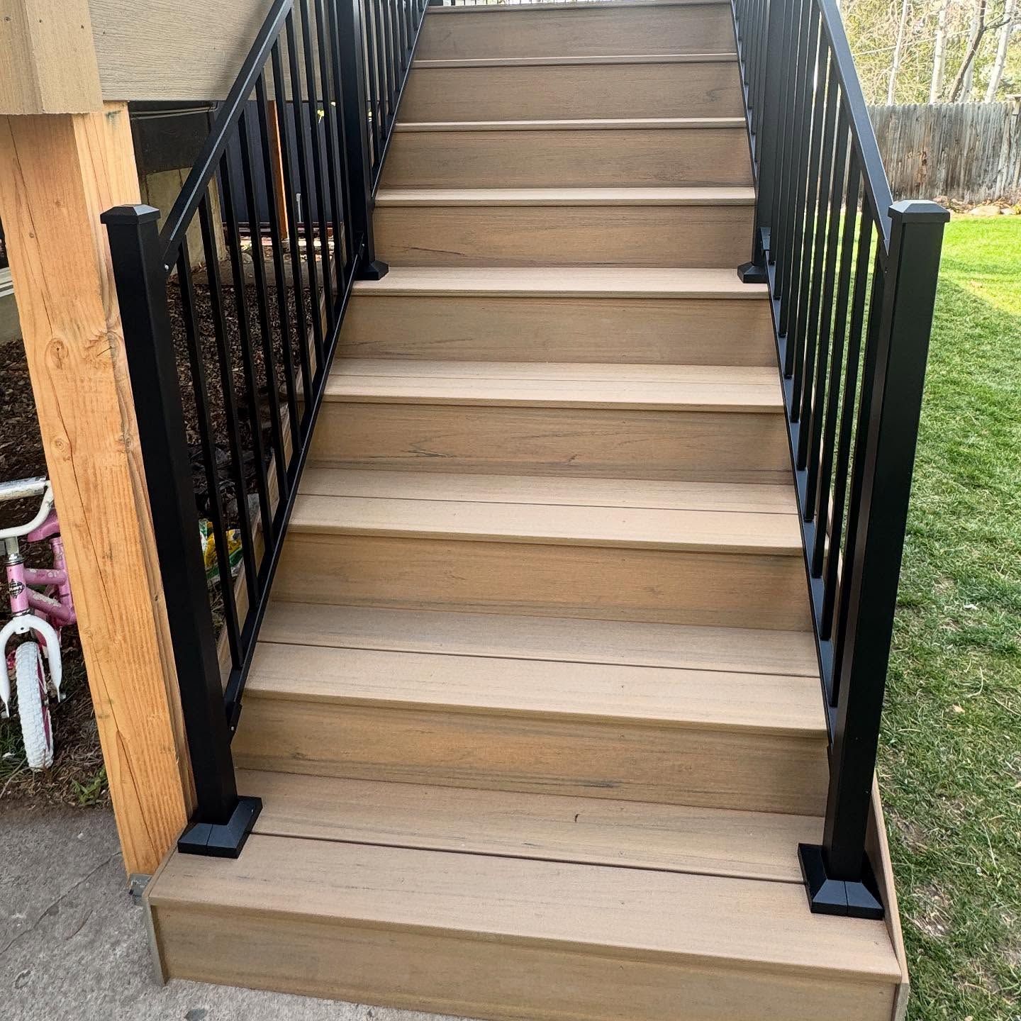 The stairs are made of wood and metal and have a black railing.
