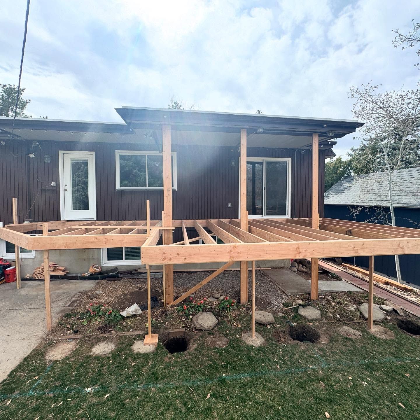 A wooden deck is being built in front of a house.