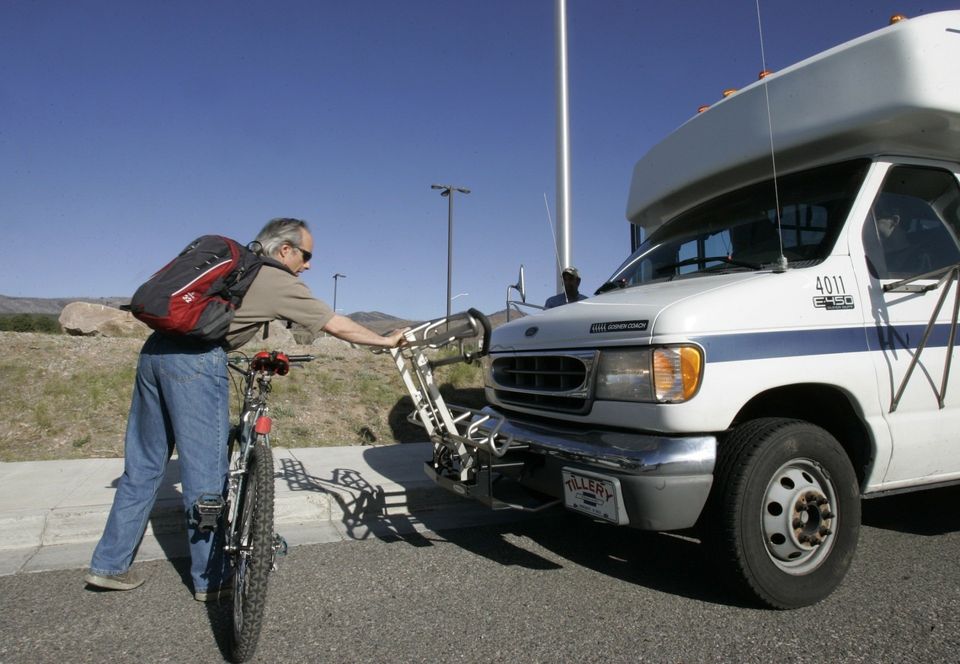 Passenger loading his bicycle on the front of bus
