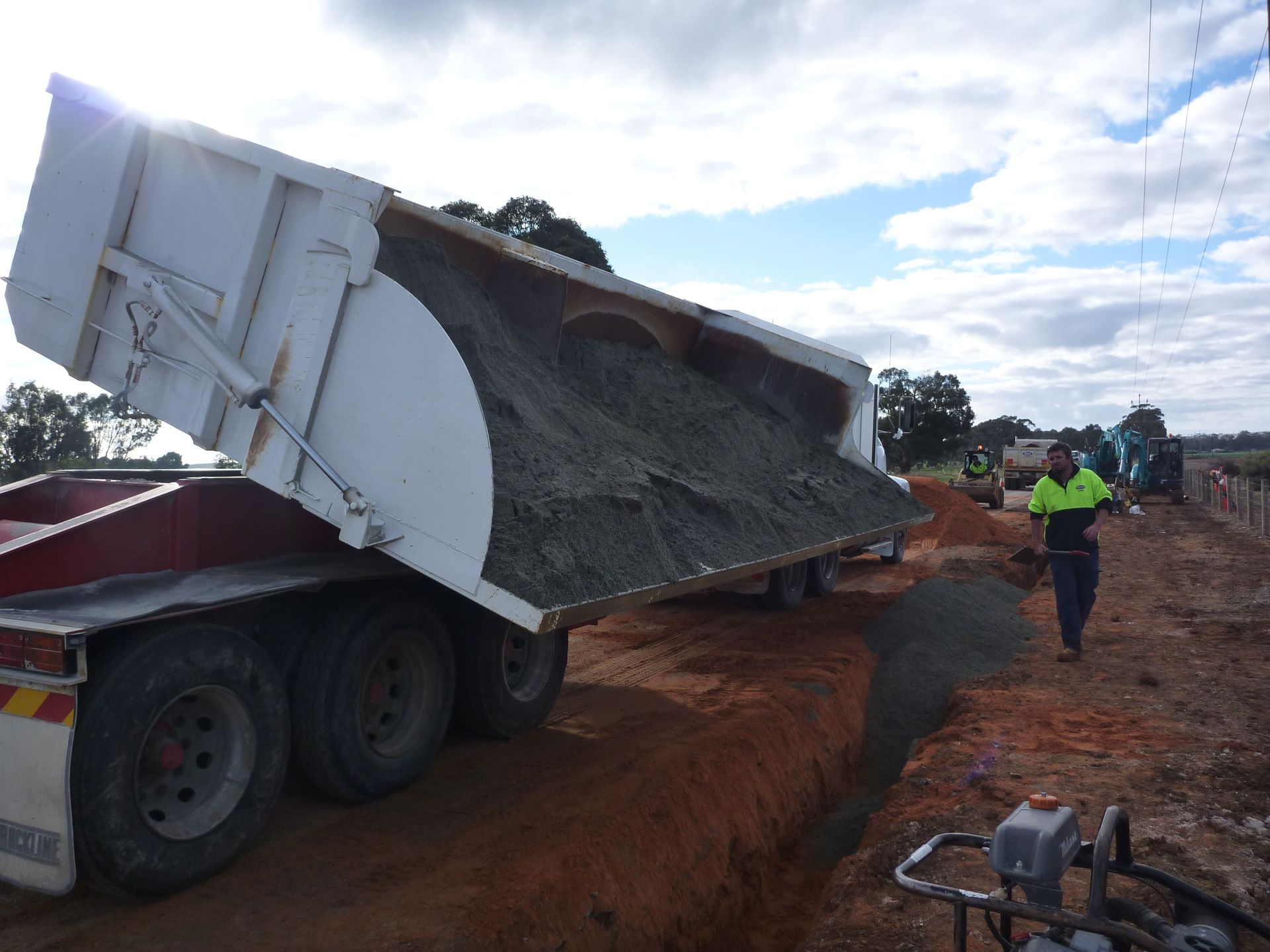 A dump truck is being loaded with dirt and a man is standing next to it | Murray Bridge, SA | Ridleys SA