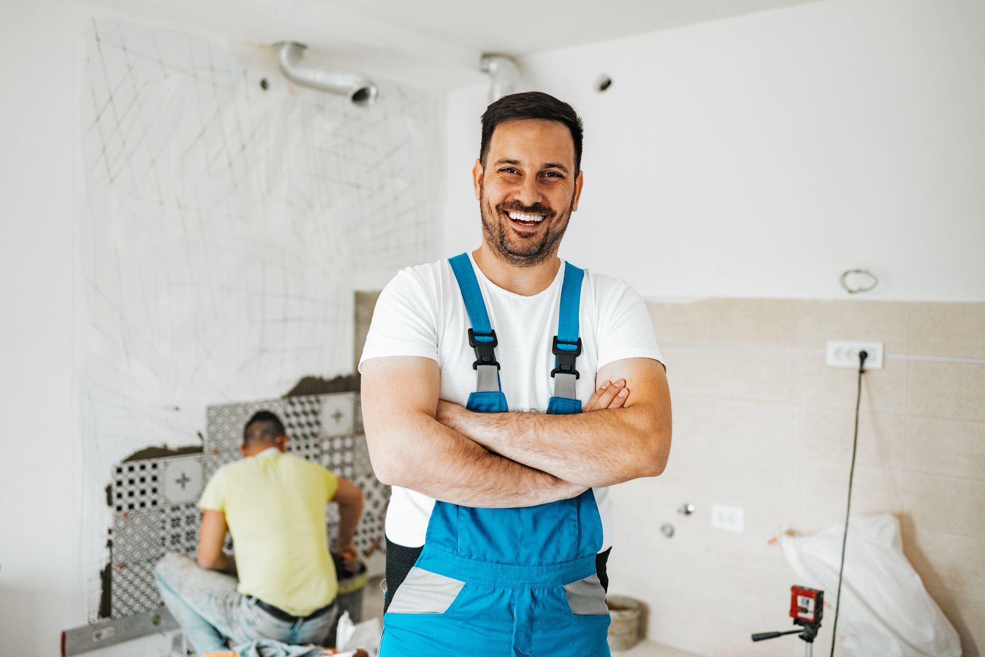 Contractor performing bathroom remodeling services, renovating modern bathroom with tools and gear.