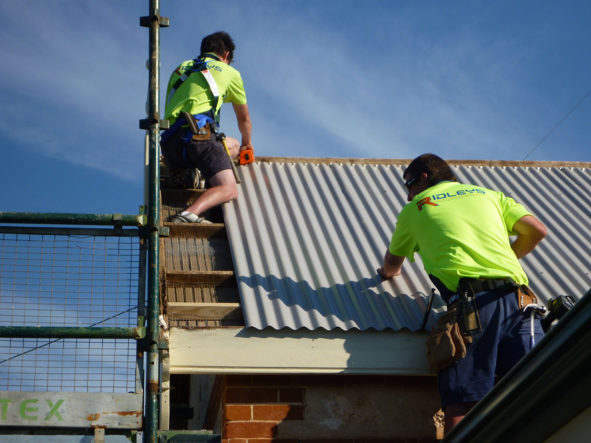 Two men are working on a roof and one is wearing a shirt that says idleve | Murray Bridge, SA | Ridleys SA 