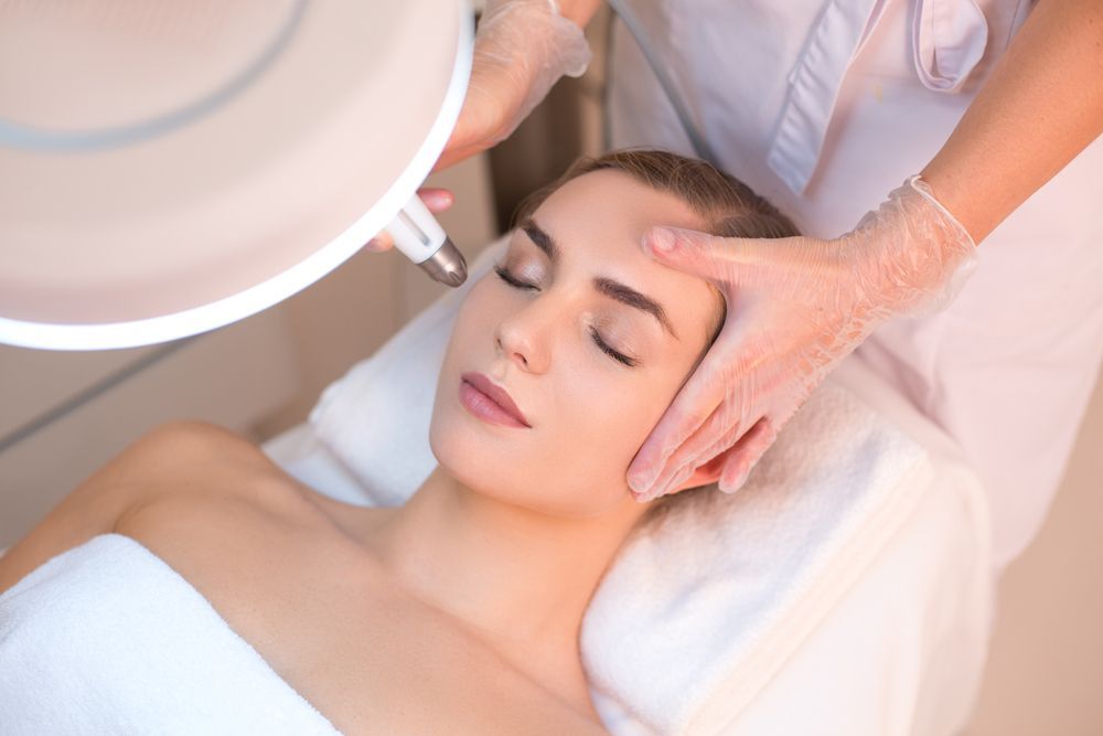 Facial Treatment as a Therapist Massages Her Forehead — Sibina Cosmetic Tattoo Art In Broadbeach, QLD