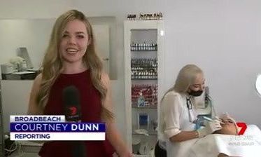 A woman is standing in front of a microphone in a beauty salon — Sibina Cosmetic Tattoo Art In Broadbeach, QLD