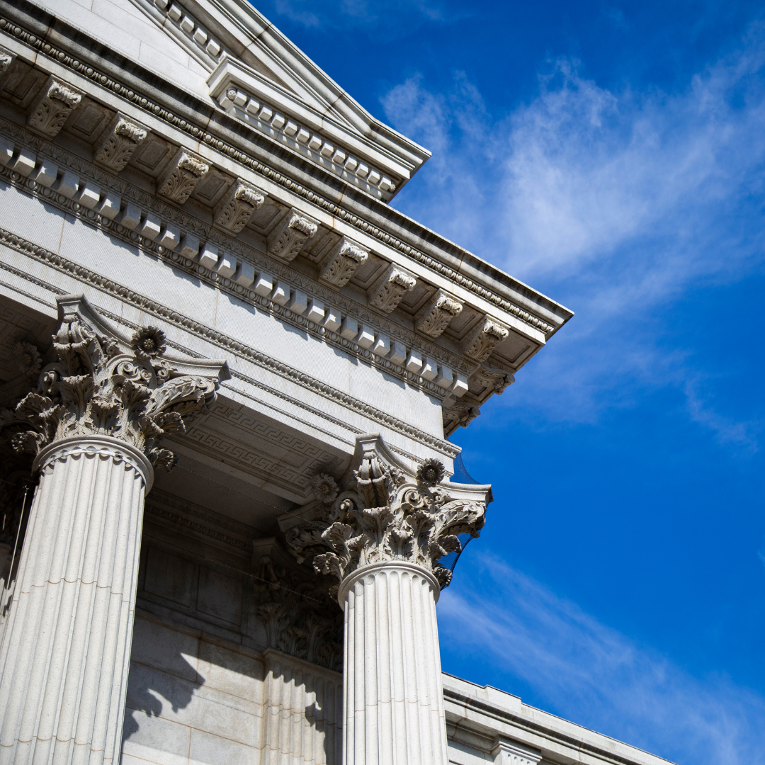 A building with columns and a blue sky in the background