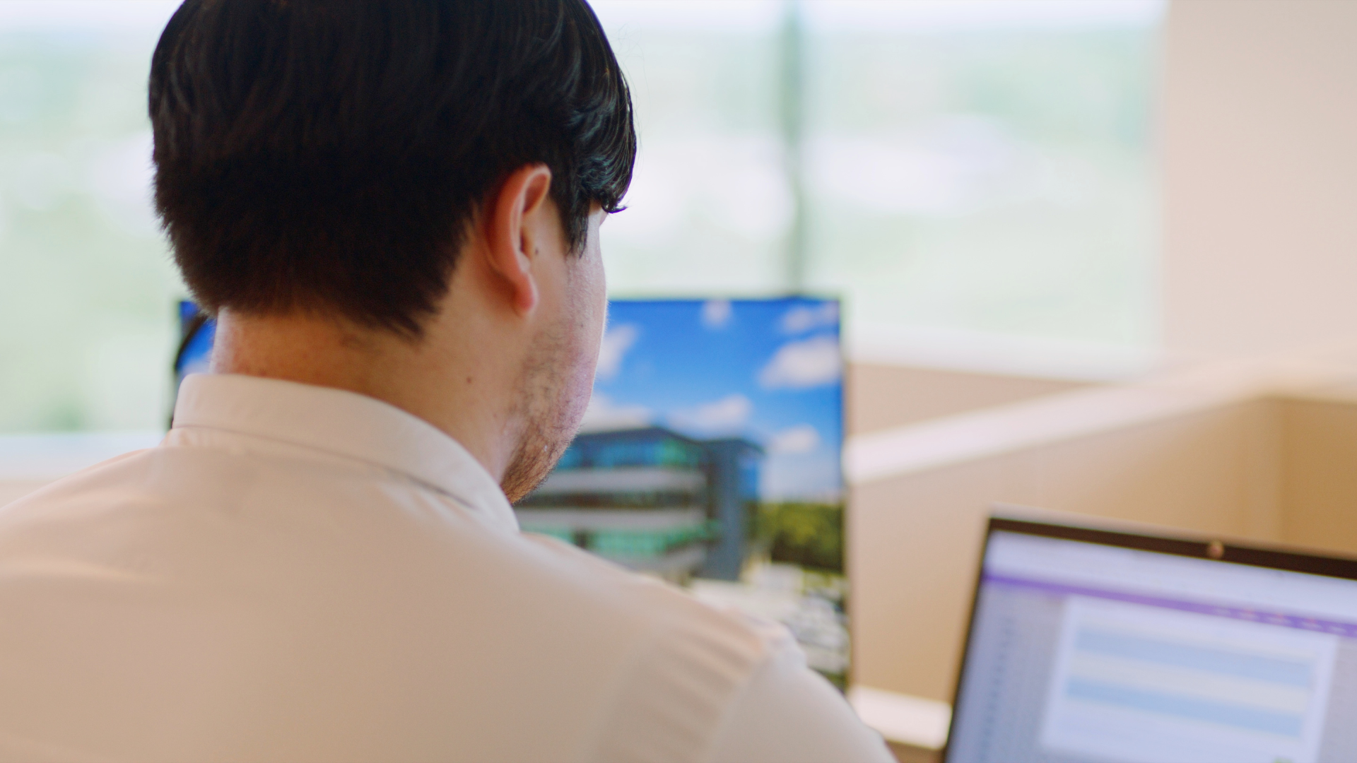 A man is sitting at a desk in front of a computer.