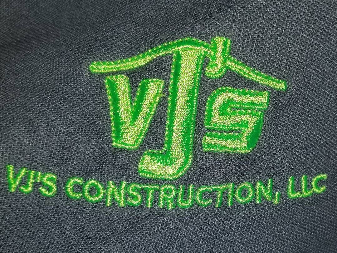 The logo for vj 's construction llc is embroidered on a black shirt.