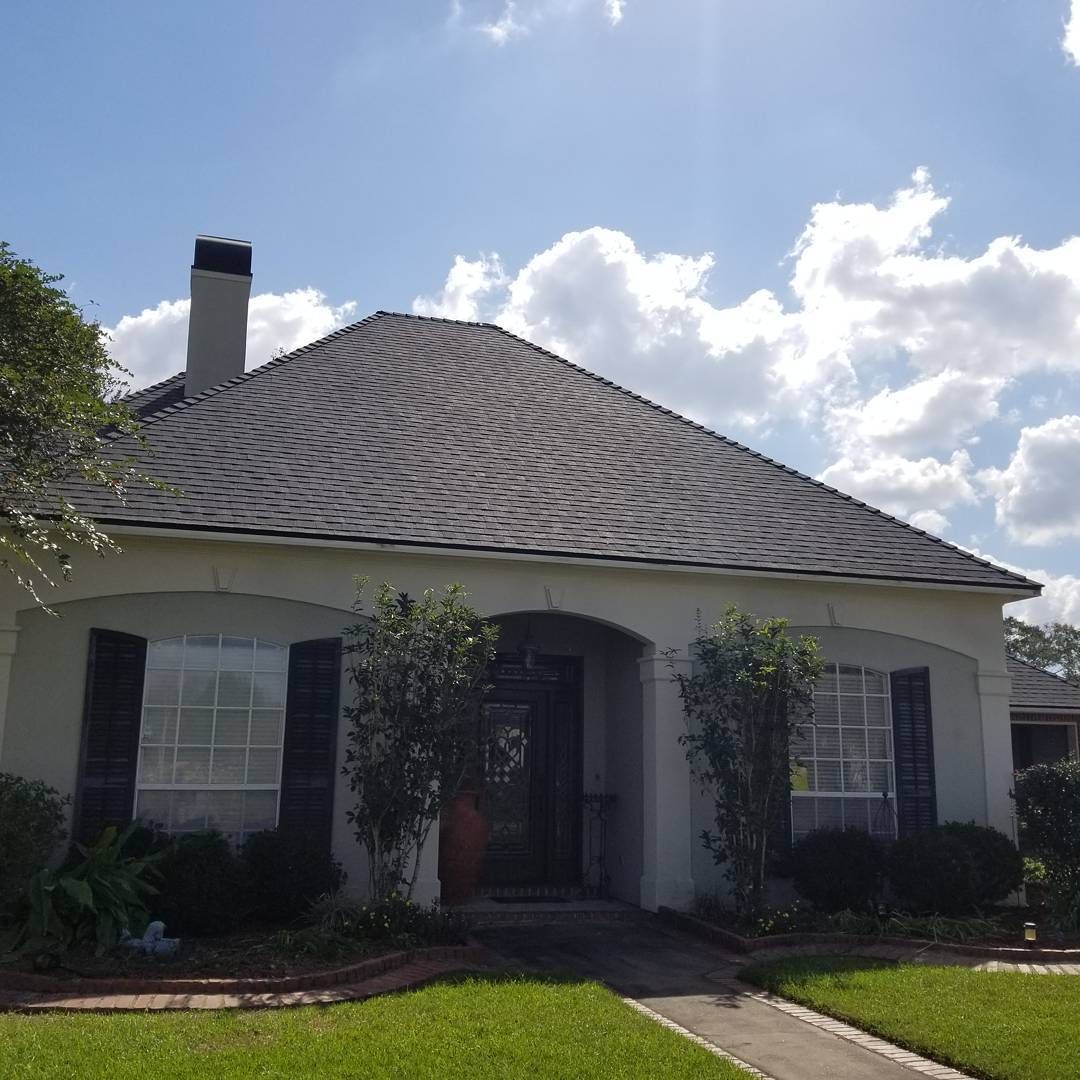 A white house with a gray roof and black shutters