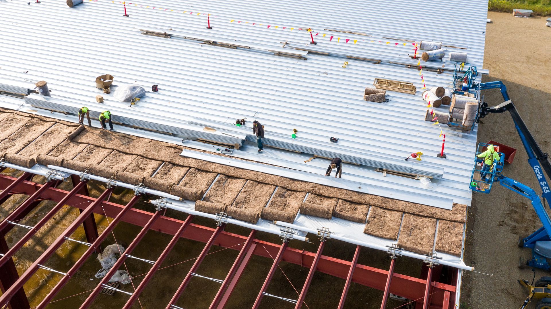 A group of construction workers are working on the roof of a building.