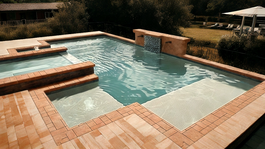 Swimming pool with brick surround and small waterfall feature, outdoors.
