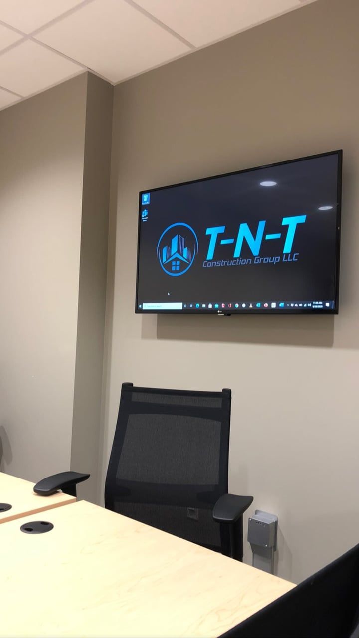A conference room with a tv on the wall that says t-n-t