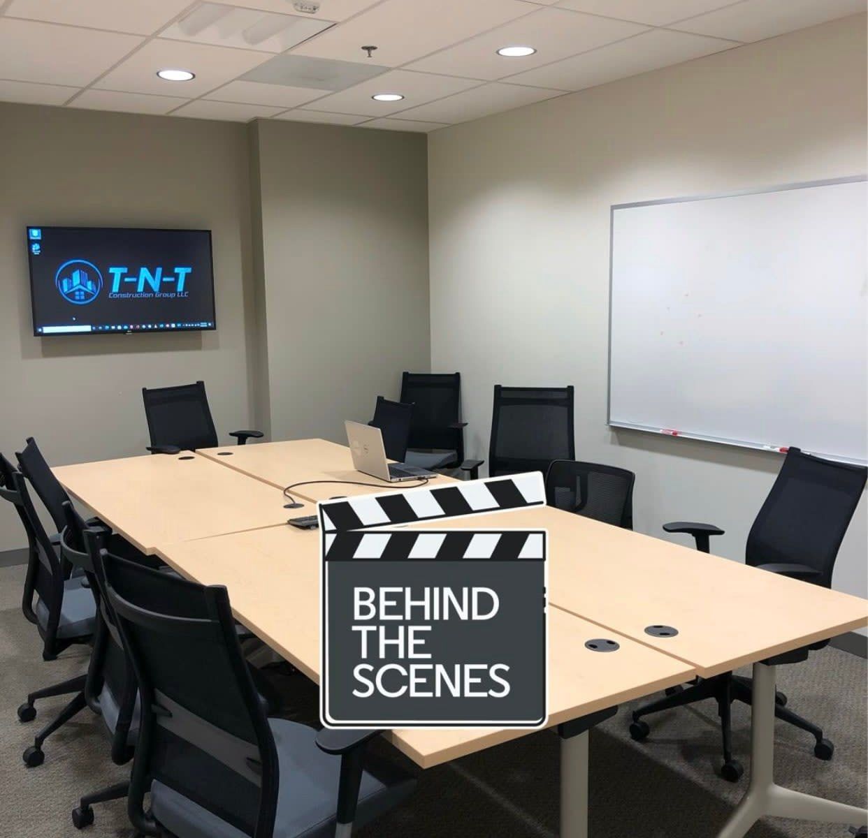 A conference room with a sign that says behind the scenes