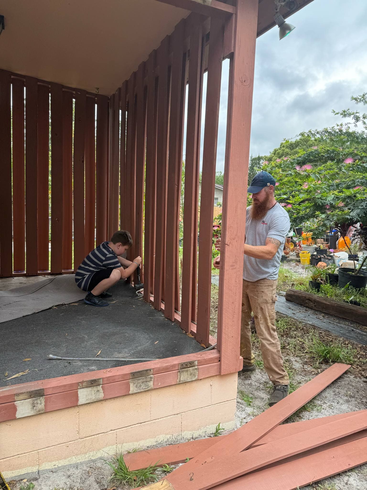 A man and a boy are working on a porch.