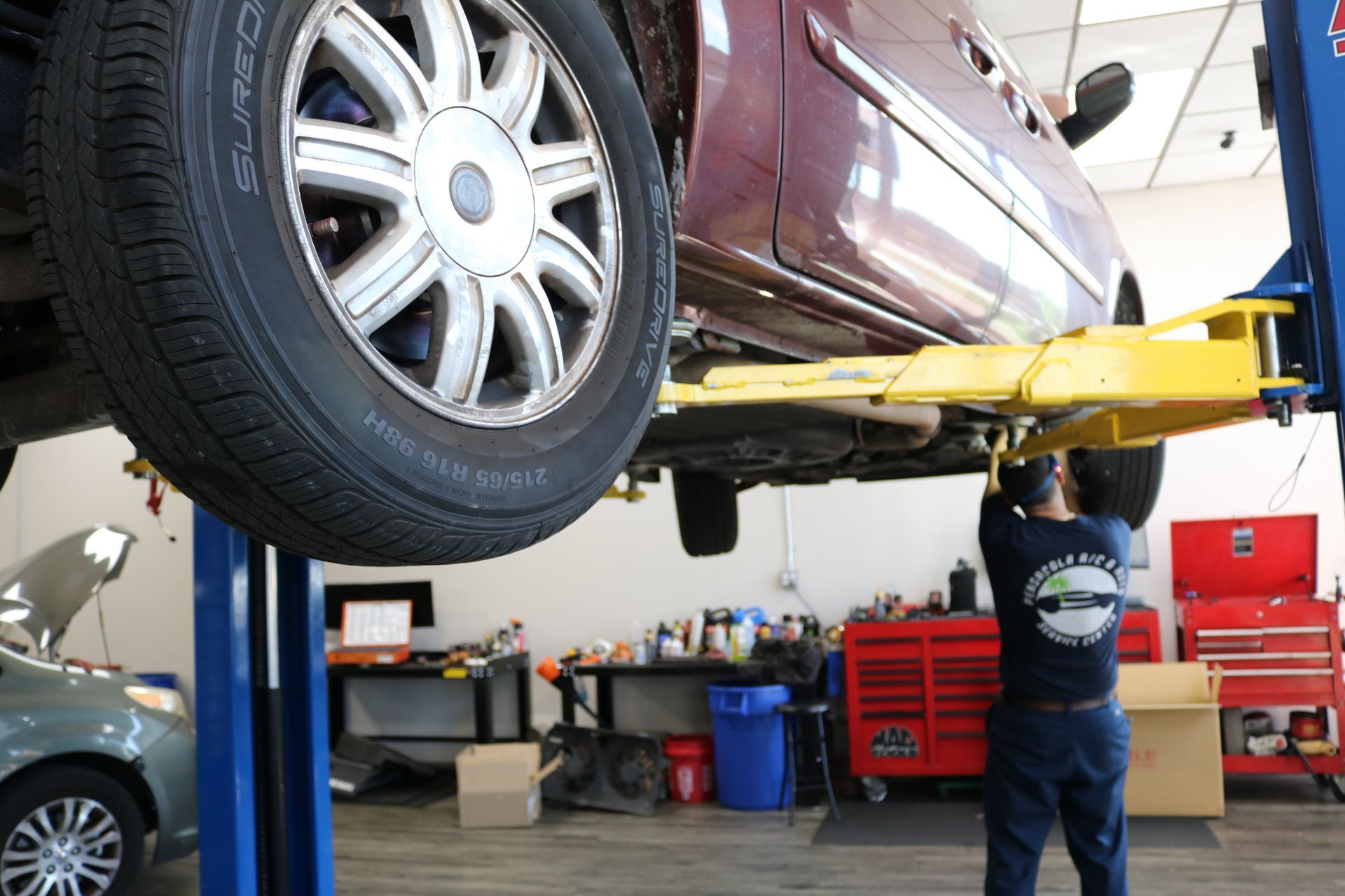 Mechanic Working on Car Under Chassis | Pensacola AC & Auto Service Center