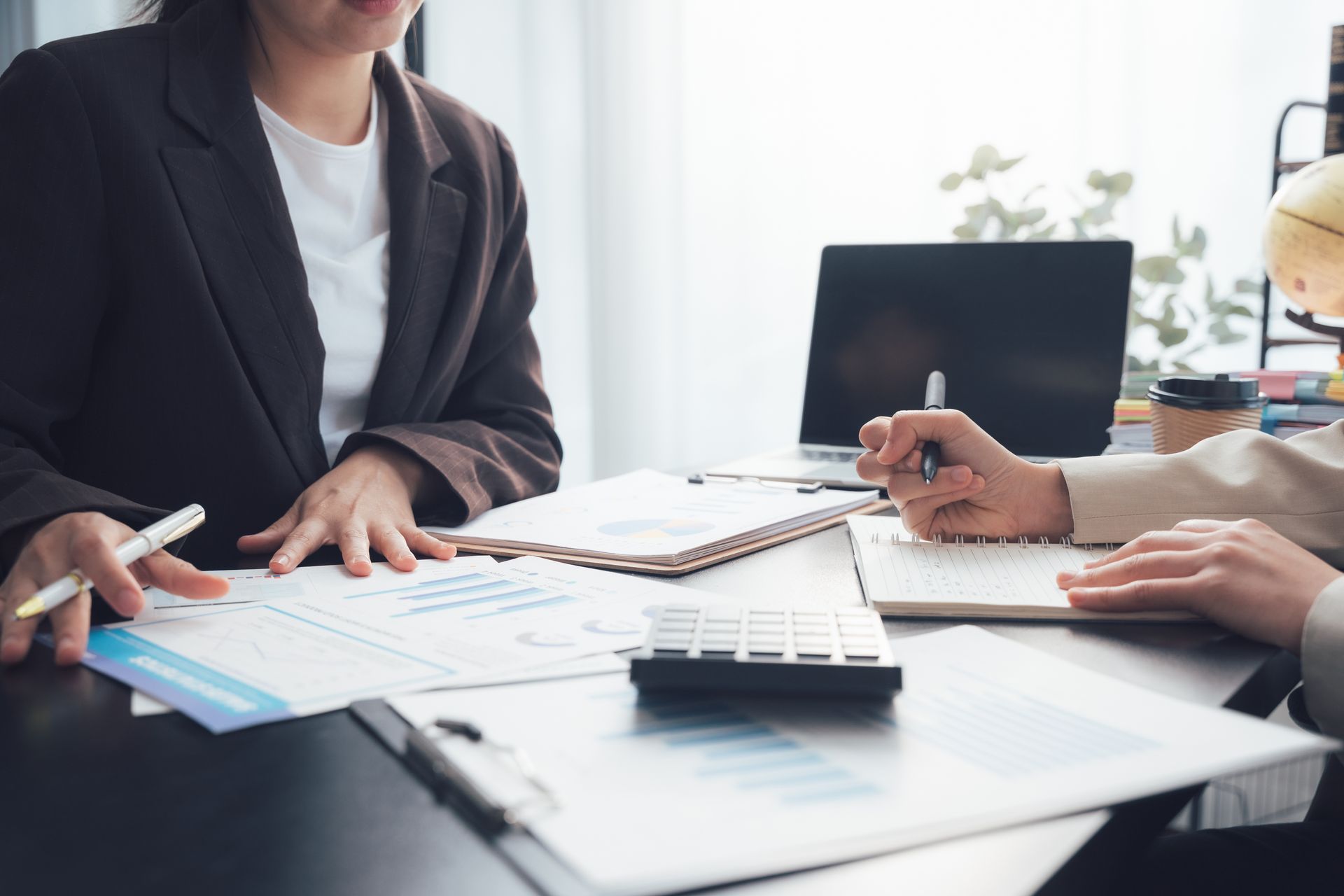 Two individuals engage in a consultation, reviewing documents for tax return preparation.